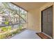 Screened in porch showcasing a view of the outdoors, lush landscaping, and front door entrance at 629 Dory Ln # 108, Altamonte Springs, FL 32714