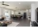 Open-concept living room with sleek gray tile, a modern kitchen, and a dining area under contemporary lighting at 741 Rioja Dr, Minneola, FL 34715