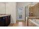 Bathroom featuring dual vanities, a separate shower, and a garden tub for relaxation at 8833 Corcovado Dr, Kissimmee, FL 34747