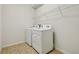 Bright laundry room with white washer and dryer, and overhead shelving at 8833 Corcovado Dr, Kissimmee, FL 34747