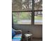 Relaxing screened porch with view of lush landscaping, wicker furniture and side table at 89 Crooked Pine Rd, Port Orange, FL 32128
