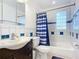 Clean bathroom with dark vanity, blue shower curtain, and glass block window at 911 Shady Park Ter, Daytona Beach, FL 32117