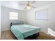 Bright bedroom with a bed, two windows, and ceiling fan at 911 Shady Park Ter, Daytona Beach, FL 32117