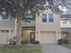 Tan two-story townhome with attached garage and landscaping at 9746 Tiramasu Trl, Orlando, FL 32829