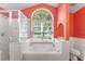 Bathroom boasts a large garden tub, shower, and an arched window at 1921 Nicholas Pl, St Cloud, FL 34771