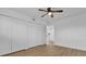 Clean bedroom with wood-look floors, closet, and ample storage with a ceiling fan at 1000 Lake Of The Woods Blvd # 203E, Casselberry, FL 32730
