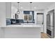 Modern kitchen with white cabinets, blue tile backsplash, and stainless steel appliances at 1000 Lake Of The Woods Blvd # 203E, Casselberry, FL 32730