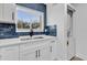 Updated kitchen featuring shaker cabinets, subway tile backsplash, stainless steel sink, and adjacent laundry at 1000 Lake Of The Woods Blvd # 203E, Casselberry, FL 32730