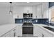 Modern kitchen with white cabinets and blue tile backsplash at 1000 Lake Of The Woods Blvd # 203E, Casselberry, FL 32730