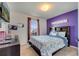 Charming bedroom with a large window, purple accent wall, and a comfortable-looking bed at 1317 Conch Key Ln, Davenport, FL 33837