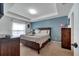 Bright main bedroom featuring a large window, tray ceiling, and a wood dresser at 1317 Conch Key Ln, Davenport, FL 33837