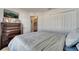 Bright bedroom featuring a dark wood dresser, mounted TV, and closet with white double doors at 1317 Conch Key Ln, Davenport, FL 33837