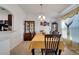Bright dining room features a modern light fixture and a decorative cabinet for storing glassware at 1317 Conch Key Ln, Davenport, FL 33837