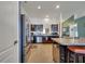 Functional kitchen featuring stainless steel appliances, dark cabinetry, a breakfast bar, and tile flooring at 1317 Conch Key Ln, Davenport, FL 33837