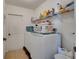 Functional laundry room with washer, dryer, and storage shelves at 1317 Conch Key Ln, Davenport, FL 33837