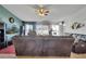 Comfortable living room featuring a large TV, ceiling fan and plush leather sofas at 1317 Conch Key Ln, Davenport, FL 33837