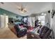 Cozy living room featuring leather sofas, a ceiling fan, a tv and large windows for natural light at 1317 Conch Key Ln, Davenport, FL 33837