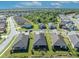 An aerial view of homes in a well-maintained neighborhood with lush green lawns and mature trees at 1511 Goblet Cove St, Kissimmee, FL 34746