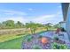 A picturesque backyard with lush grass, palm trees, and a patio with a lounge chair at 1511 Goblet Cove St, Kissimmee, FL 34746