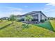 Large grassy backyard with a patio and tropical landscaping surrounding the home's exterior at 1511 Goblet Cove St, Kissimmee, FL 34746