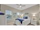 Bright bedroom featuring a white bed frame, coastal decor, ample natural light through large windows at 1511 Goblet Cove St, Kissimmee, FL 34746