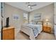 Bedroom featuring a wooden bed frame, coastal decor, ample natural light through a window, and ceiling fan at 1511 Goblet Cove St, Kissimmee, FL 34746