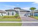 Charming single-story home with a tile roof, paver driveway, well-manicured lawn, and lush landscaping at 1511 Goblet Cove St, Kissimmee, FL 34746