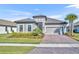 Charming single-story home with a tile roof, paver driveway, well-manicured lawn, and lush landscaping at 1511 Goblet Cove St, Kissimmee, FL 34746