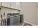 A laundry room featuring modern washer and dryer units, overhead white cabinets, and contemporary flooring at 1511 Goblet Cove St, Kissimmee, FL 34746