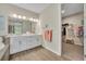 Elegant main bathroom featuring double sinks, a soaking tub, and a doorway to a walk-in closet at 1511 Goblet Cove St, Kissimmee, FL 34746
