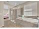 Bright main bathroom features a glass shower, a soaking tub, and neutral tile flooring at 1511 Goblet Cove St, Kissimmee, FL 34746