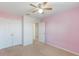 Bedroom with pink walls, double doors, and access to hallway at 15508 Blackbead St, Winter Garden, FL 34787