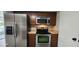 Stainless steel appliances and wood cabinets in this galley kitchen at 203 Crown Oaks Way # 202, Longwood, FL 32779