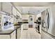 Bright kitchen featuring white cabinets, stainless steel appliances, and an open layout to the dining area at 2537 Lanier Rd, Kissimmee, FL 34744