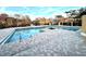 Community pool with brick patio and lake view at 4524 Commander Dr # 1613, Orlando, FL 32822