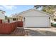 House exterior featuring a white garage door and red wooden fence at 4714 S Peninsula Dr, Ponce Inlet, FL 32127