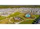 Aerial view showcasing the community's homes, a central park, pool, and playground at 494 Amadoras Way, St Cloud, FL 34771