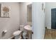 Small bathroom with white toilet, pedestal sink, decorative artwork, and dark wooden floors at 494 Amadoras Way, St Cloud, FL 34771