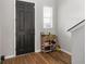 Hallway with a dark front door, wood floors, and a shoe organizer at 494 Amadoras Way, St Cloud, FL 34771