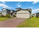 Charming two-story home featuring a brick driveway and attached two-car garage with a well manicured lawn at 494 Amadoras Way, St Cloud, FL 34771