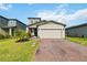Charming two-story home featuring a brick driveway and attached two-car garage with a well manicured lawn at 494 Amadoras Way, St Cloud, FL 34771