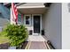 Inviting front porch with American flag, decorative shrubbery, and a dark-colored front door at 494 Amadoras Way, St Cloud, FL 34771