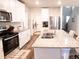 Modern kitchen with white cabinets, granite countertops, and stainless steel appliances at 494 Amadoras Way, St Cloud, FL 34771