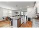 Modern kitchen island with stainless steel dishwasher, sink, and granite countertops adjacent to dining area at 494 Amadoras Way, St Cloud, FL 34771
