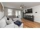 Cozy living room features a large sectional sofa, ceiling fan, and sliding glass doors for natural light at 494 Amadoras Way, St Cloud, FL 34771