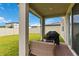 Covered patio featuring seating area, grill, and an outdoor view of the beautifully maintained green yard at 494 Amadoras Way, St Cloud, FL 34771