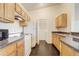 Kitchen with light wood cabinets, white appliances, and black countertops at 5961 Westgate Dr # 2034, Orlando, FL 32835