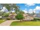 Tan house with a brick driveway and green lawn at 615 Tuskawilla Point Ln, Winter Springs, FL 32708
