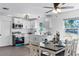 Well-lit kitchen boasts white cabinetry, stainless appliances, and a dining table with set tableware at 720 Jasmine Ave, Orange City, FL 32763