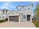 Two-story house with gray siding, stone accents, and a brown garage door at 7783 Westland Dr, Kissimmee, FL 34747